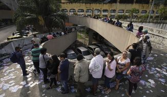 Voters wait in line at a polling station in the Rocinha favela in Rio de Janeiro, Brazil, Sunday, Oct. 7, 2018. Brazilians choose among 13 candidates for president Sunday in one of the most unpredictable and divisive elections in decades. If no one gets a majority in the first round, the top two candidates will compete in a runoff.  (AP Photo/Ricardo Borges)