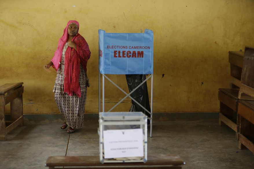 A women exits a polling booth during the Presidential elections in Briqueterie Cameroon, Sunday Oct. 7, 2018. Polls opened Sunday in Cameroon as Africa's oldest leader is widely expected to win another term, while separatists threaten to disrupt the election and many people who have fled the unrest are unable to vote. (AP Photo/Sunday Alamba)
