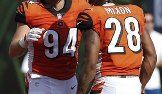 Cincinnati Bengals defensive end Sam Hubbard (94) celebrates his touchdown on a fumble return with running back Joe Mixon (28) during the second half of an NFL football game against the Miami Dolphins in Cincinnati, Sunday, Oct. 7, 2018. (AP Photo/Frank Victores)