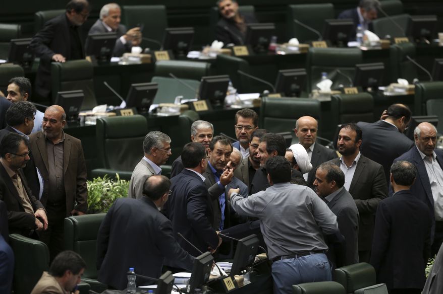 A group of lawmakers talk during an open session of parliament in Tehran, Iran, Sunday, Oct. 7, 2018. Iran’s parliament voted Sunday to join a global convention to cut off terror financing, hoping to avoid further international sanctions as the 2015 nuclear accord unravels. (AP Photo/Vahid Salemi)