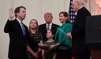 Retired Justice Anthony M. Kennedy swore in Justice Brett M. Kavanaugh in a ceremony Monday hosted by President Trump. Ashley Kavanaugh held the Bible, and their daughters, Margaret (left) and Liza, looked on. (Associated Press)