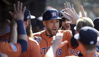 Houston Astros&#39; George Springer is congratulated by teammates after hitting a solo home run off Cleveland Indians starting pitcher Mike Clevinger in the fifth inning during Game 3 of baseball&#39;s American League Division Series, Monday, Oct. 8, 2018, in Cleveland. (AP Photo/David Dermer)