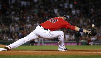 Boston Red Sox first baseman Mitch Moreland cannot get a glove on a throw to first after a base hit by New York Yankees&#x27; Aaron Judge during the fifth inning of Game 2 of a baseball American League Division Series, Saturday, Oct. 6, 2018, in Boston. (AP Photo/Elise Amendola)