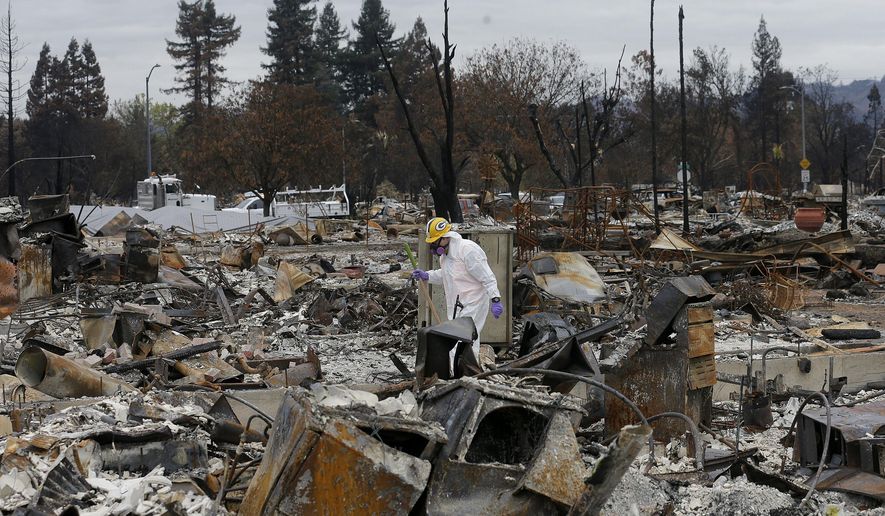 FILE - In this Nov. 8, 2017, file photo, work crews remove debris at the site of a home destroyed by fires in the Coffey Park area of Santa Rosa, Calif. California Office of Emergency Services Director Mark Ghilarducci complained to the Army that contractors it paid by the ton to clear debris took too much dirt and damaged or removed perfectly fine driveways, retaining walls and the like after the 2017 wine country fire that destroyed thousands of homes. (AP Photo/Jeff Chiu, File)