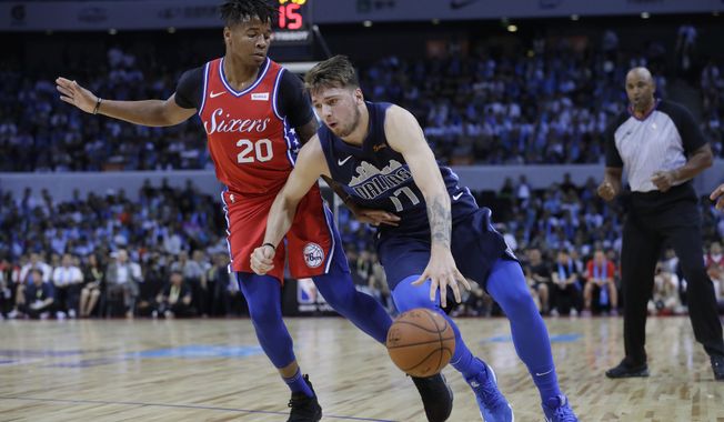 Luka Doncic of the Dallas Mavericks, right, controls the ball past Markelle Fultz of the Philadelphia 76ers, during the Shenzhen basketball match between the Philadelphia 76ers and the Dallas Maverick, part of the NBA China Games, in Shenzhen city, south China&#x27;s Guangdong province, Monday, Oct. 8, 2018. (AP Photo/Kin Cheung)