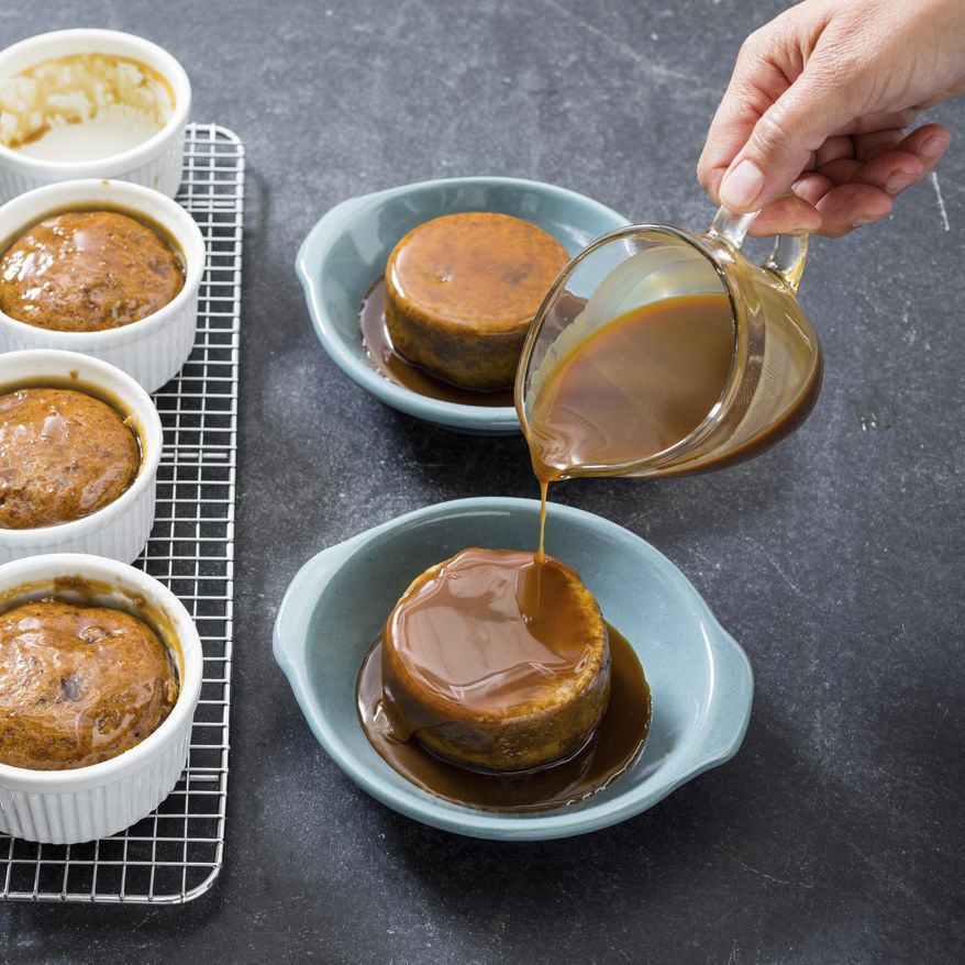 This undated photo provided by America's Test Kitchen in September 2018 shows individual sticky butterscotch pudding cakes in Brookline, Mass. This recipe appears in the cookbook “Just Add Sauce.” (Daniel J. van Ackere/America's Test Kitchen via AP)
