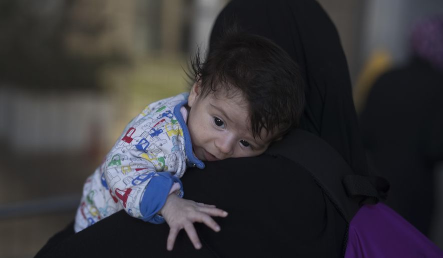 One month Sonia Al Taie who lives with 6 family members in Malakasa refugee camp, on the outskirt of Athens takes part in a protest against the living conditions at the camp, outside the Ministry of Migration in Nikea, suburb of Athens, Monday, Oct. 8, 2018. (AP Photo/Petros Giannakouris)