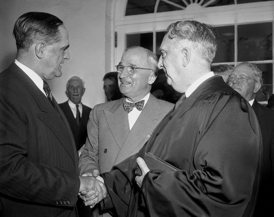 FILE - In this Oct. 12, 1949, file photo, President Harry S. Truman, center, and Chief Justice Fred Vinson, right, congratulates Sherman Minton, left, outside the White House after Minton was sworn in by Vinson as an Associate Justice of the Supreme Court, in Washington, D.C. That relationship between the White House and the Supreme Court is being examined anew following the bitter confirmation fight over Brett Kavanaugh, who angrily denounced President Donald Trump’s political opponents during a Senate hearing. (AP Photo/John Rous, File)