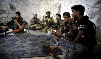 FILE - In this Sunday, Sept. 9, 2018 file photo, fighters with the Free Syrian army eat in a cave where they live, on the outskirts of the northern town of Jisr al-Shughur, Syria, west of the city of Idlib. Turkey&#39;s state-run Anadolu Agency news agency said Monday, Oct. 8, 2018, that Syrian rebels have finished withdrawing all their heavy weapons from the front lines in the northwestern province of Idlib. The move was part of a deal reached between Russia and Turkey to demilitarize the front lines between Syrian government forces and the opposition in and around the province. Idlib is the last major rebel stronghold in Syria. (Ugur Can/DHA via AP, File)