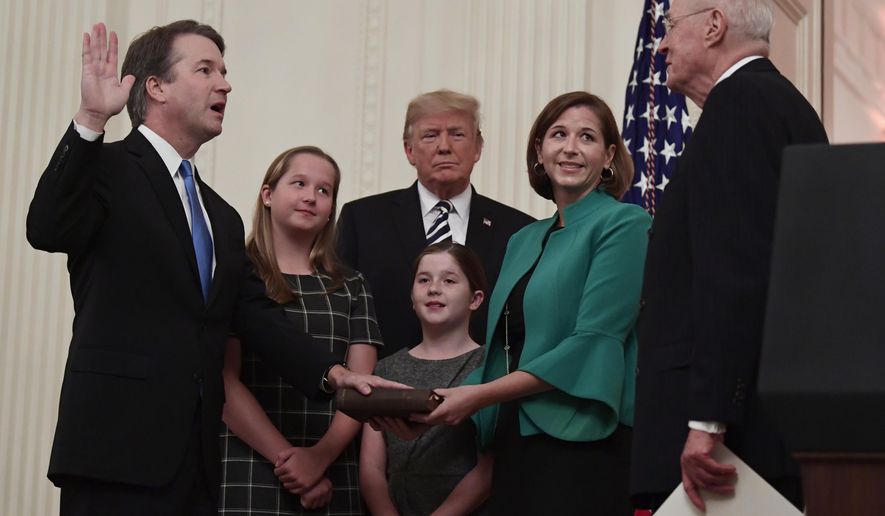 President Donald Trump, center, listens as retired Supreme Court Justice Anthony Kennedy, right, ceremonially swears-in Supreme Court Justice Brett Kavanaugh, left, in the East Room of the White House in Washington, Monday, Oct. 8, 2018. Kavanaugh's wife Ashley watches, second from right with daughters Margaret, left, and Liza. (AP Photo/Susan Walsh)