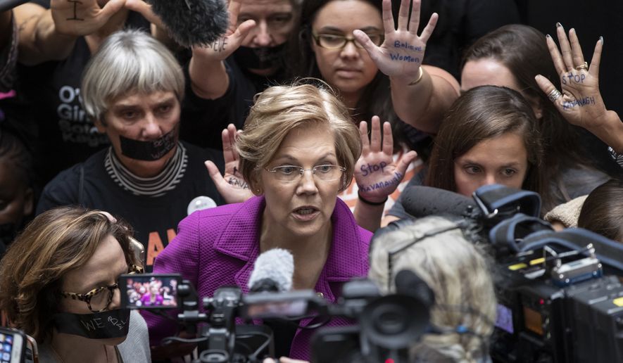 In a Thursday, Sept. 27, 2018 file photo, Sen. Elizabeth Warren, D-Mass., greets womens&#x27; rights activists in the Hart Senate Office Building as the Senate Judiciary Committee hears from Brett Kavanaugh and Christine Blasey Ford, his accuser, on Capitol Hill in Washington. Warren, along with Ayanna Pressley, fresh off her primary victory over 10-term U.S. Rep. Michael Capuano in Massachusetts, were in Jonesboro on Tuesday, Oct. 9. 2018 with Democratic candidate Stacey Abrams.  (AP Photo/J. Scott Applewhite, File)