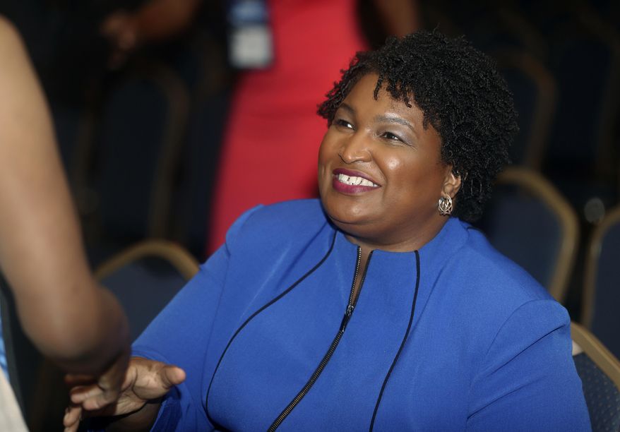 FILE- In this Aug. 3, 2018, file photo, Georgia gubernatorial candidate Stacey Abrams is greeted before speaking at the National Association of Black Journalists in Detroit. With less than a month before November's election, the hotly contested race for Georgia governor is attracting visits from national heavyweights that show just how seriously both Democrats and Republicans are taking the race. (AP Photo/Carlos Osorio, File)