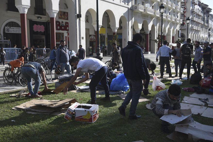 Migrants clear the Aristotelous Square in the northern Greek city of Thessaloniki, Monday, Oct. 8, 2018. Several hundred asylum-seekers camped outside a police station in Greece's second-largest city Thessaloniki, lining up to be arrested and formally processed, as a surge in illegal migration in northern Greece has overwhelmed authorities. (AP Photo/Giannis Papanikos)