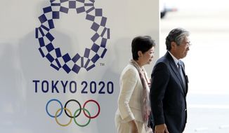 FIEL - In this Aug. 24, 201, file photo, Tokyo Gov. Yuriko Koike, second from right, and Tsunekazu Takeda, president of the Japanese Olympic Committee, walk past the logo of the Tokyo 2020 Olympics during the Olympic flag arrival ceremony at Haneda international airport in Tokyo. The price tag keeps soaring for the 2020 Tokyo Olympics despite local organizers and the International Olympic Committee saying that spending is being cut. (AP Photo/Eugene Hoshiko, File)