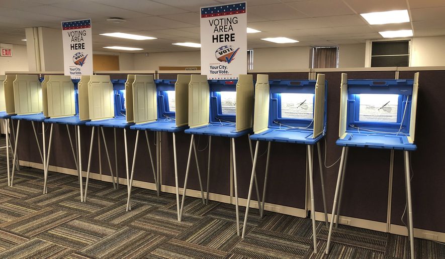 In this Sept. 20, 2018 photo, voting booths stand ready in downtown Minneapolis for the opening of early voting in Minnesota. Minnesota and South Dakota are tied for the earliest start in the country for early voting in the 2018 midterm elections. A new poll finds that a large majority of Americans are concerned the nation’s voting systems might be vulnerable to hackers, with Democrats more concerned than Republicans.  (AP Photo/Steve Karnowski)