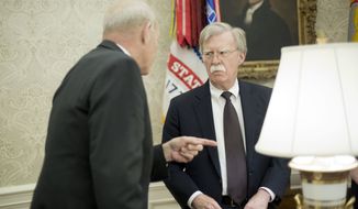 White House Chief of Staff John Kelly, left, talks with, White House National Security Advisor John Bolton, right, in the Oval Office of the White House in Washington during President Donald Trump&#39;s meeting to discuss potential damage from Hurricane Michael, Wednesday, Oct. 10, 2018. (AP Photo/Pablo Martinez Monsivais)