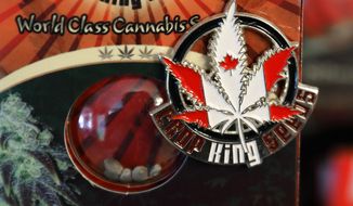 In this Sept. 24, 2018 photo, a pin promoting Crop King Seeds, with the colors and maple-leaf logo of the Canadian flag, is displayed on a package of marijuana seeds for sale at the Warmland Centre, a medical marijuana dispensary in Mill Bay, British Columbia, on Vancouver Island in Canada. On Oct. 17, 2018, Canada will become the second and largest country with a legal national marijuana marketplace. (AP Photo/Ted S. Warren)