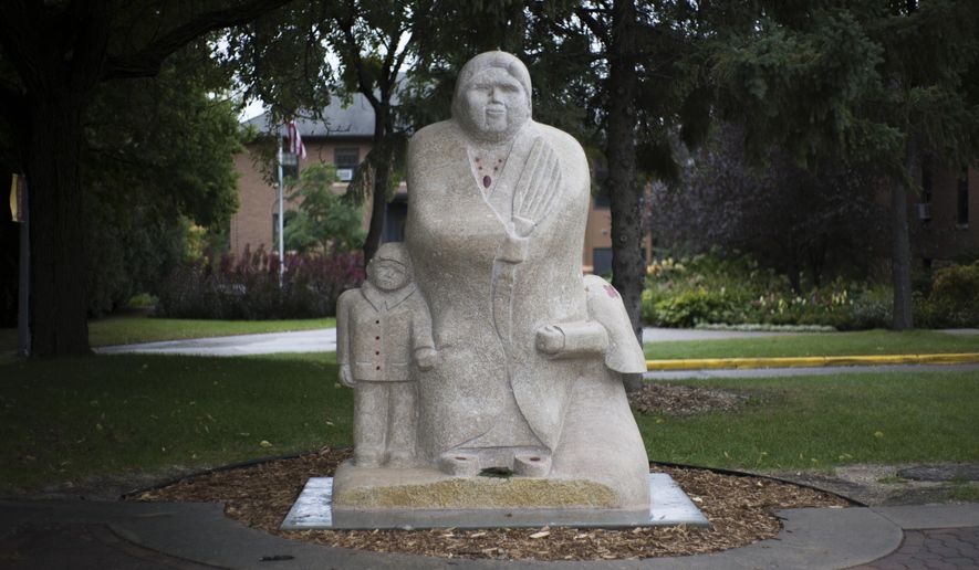 The Goodwin Statue sits across from the Multi-Ethnic Resource Center on Wednesday, Oct. 3, 2018, at the University of Minnesota-Morris campus. Duane Goodwin carved the traditional Anishinaabe stone statue. (Ellen Schmidt/The Minnesota Daily via AP)