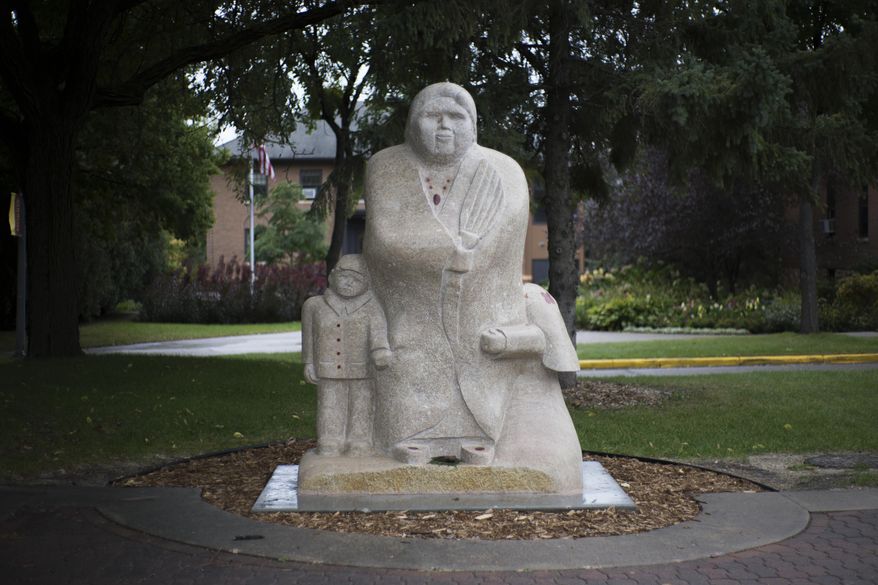 The Goodwin Statue sits across from the Multi-Ethnic Resource Center on Wednesday, Oct. 3, 2018, at the University of Minnesota-Morris campus. Duane Goodwin carved the traditional Anishinaabe stone statue. (Ellen Schmidt/The Minnesota Daily via AP)