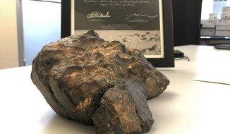 A 12-pound (5.5 kilogram) lunar meteorite discovered in Northwest Africa in 2017 rests on a table, in Amherst, N.H. The rock, which is actually comprised of six fragments that fit together like a puzzle, was found last year in a remote area of Mauritania, but may have plunged to Earth thousands of years ago. The meteorite could sell for $500,000 or more at an online auction that runs from Thursday, Oct. 11, until Oct. 18, 2018. (AP Photo/Rodrique Ngowi)