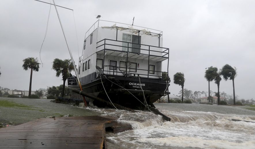 The Oceanis is grounded by a tidal surge at the Port St. Joe Marina, Wednesday, Oct. 10, 2018 in Port St. Joe, Fla. Supercharged by abnormally warm waters in the Gulf of Mexico, Hurricane Michael slammed into the Florida Panhandle with terrifying winds of 155 mph Wednesday, splintering homes and submerging neighborhoods. (Douglas R. Clifford/Tampa Bay Times via AP)
