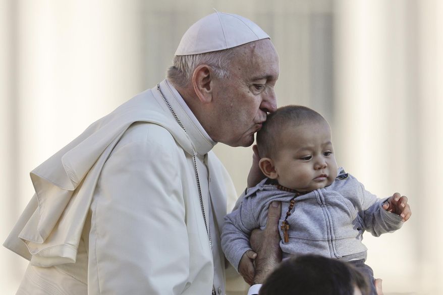 Pope Francis kisses a child as he arrives with the popemobile in St. Peter's Square to held his weekly general audience at the Vatican, Wednesday, Oct. 10, 2018. (AP Photo/Gregorio Borgia)
