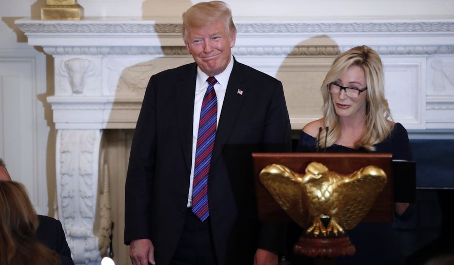 President Donald Trump smiles as pastor Paula White prepares to lead the room in prayer, during a dinner for evangelical leaders in the State Dining Room of the White House, Monday, Aug. 27, 2018, in Washington. (AP Photo/Alex Brandon) ** FILE **