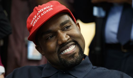 Rapper Kanye West smiles as he listens to a question from a reporter during a meeting in the Oval Office of the White House with President Donald Trump, Thursday, Oct. 11, 2018, in Washington. (AP Photo/Evan Vucci)