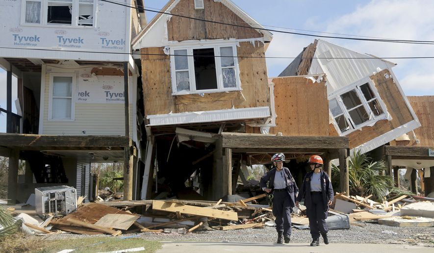 Emergency workers Dr. Patricia Cantrell, left, and Ana Kaufmann, with the South Florida Search and Rescue Task Force 2, survey damage at the western edge of town in Mexico Beach, Fla., after Hurricane Michael swept through the area Thursday, Oct. 11, 2018. (Douglas R. Clifford/Tampa Bay Times via AP)