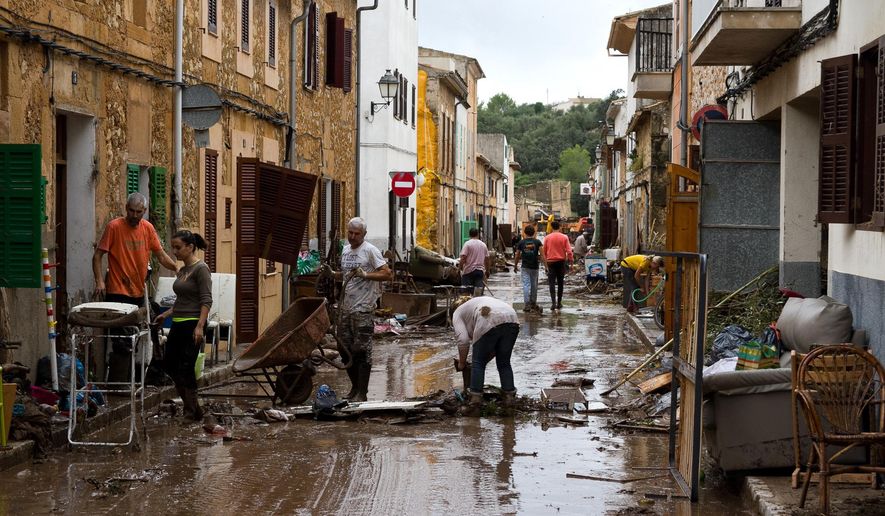 Residents clear mud from a flooded dstreet in Sant Llorenc, 60 kilometers (40 miles) east of Mallorca&#x27;s capital, Palma, Spain, on Wednesday, Oct. 10, 2018. Torrential rainstorms that caused flash flooding of water and mud on the Spanish island of Mallorca killed at least nine people, authorities said on Wednesday. (AP Photo/Francisco Ubilla)