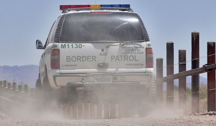 In this May 26, 2006, photo, a U.S. Border Patrol agent patrols the international border separating Sonoyta, Mexico, right of fence, and Lukeville, Ariz., in Organ Pipe Cactus National Monument. (AP Photo/Matt York)
