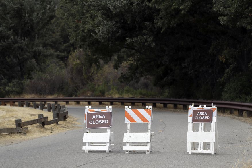 Signs indicate a road closure at the Malibu Creek State Park Thursday, Oct. 11, 2018, in Calabasas, Calif. Investigators will use ballistic testing to determine if a rifle carried by a burglary suspect was used in the killing of a camper at the California wilderness park. Authorities say 42-year-old Anthony Rauda had the gun and was dressed in black when he was arrested Wednesday after a search of a rugged canyon area near Malibu. (AP Photo/Marcio Jose Sanchez)