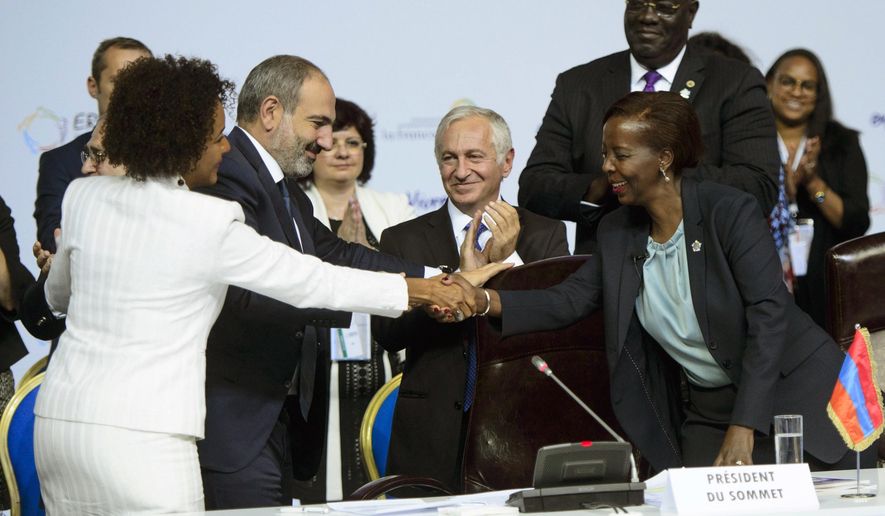 Outgoing Secretary-General of the Francophonie, Michaelle Jean, left, shakes hands with Secretary-General designate Louise Mushikiwabo during the closing session of the Francophonie Summit in Yerevan, Armenia on Friday, Oct. 12, 2018. (Sean Kilpatrick/The Canadian Press via AP)