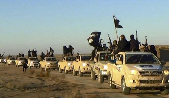 In this undated file photo released online in the summer of 2014 on a militant social media account, which has been verified and is consistent with other AP reporting, militants of the Islamic State group hold up their weapons and wave its flags on their vehicles in a convoy on a road leading to Iraq, in Raqqa, Syria. With Islamic State&#39;s near total defeat on the battle field, the extremist group has reverted to what it was before its spectacular series of conquests in 2014 _ a shadowy terror network that targets vulnerable civilian populations and exploits state weaknesses to incite on sectarian strife. But a recent surge in false claims of responsibility for attacks also signals that the group is struggling to stay relevant after losing its proto-state and its dominance of the international news agenda. (Militant photo via AP, File)