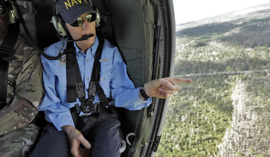 Florida Gov. Rick Scott points out some damage caused by Hurricane Michael while flying somewhere over the panhandle of Florida Thursday, Oct. 11, 2018. The devastation inflicted by Hurricane Michael came into focus Thursday with rows upon rows of homes found smashed to pieces, and rescue crews began making their way into the stricken areas in hopes of accounting for hundreds of people who may have stayed behind. (AP Photo/Chris O&#x27;Meara)