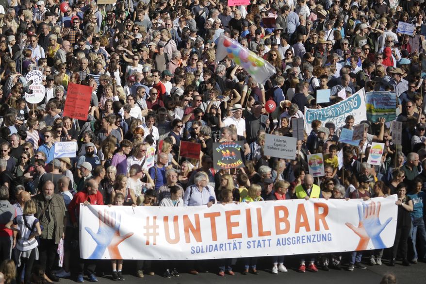 Thousands of people attend a demonstration with the slogan 'indivisible' against hate and four solidarity instead of exclusion in Berlin, Germany, Saturday, Oct. 13, 2018. The main poster reads: 'indivisible- solidarity instead of exclusion'. (AP Photo/Markus Schreiber)