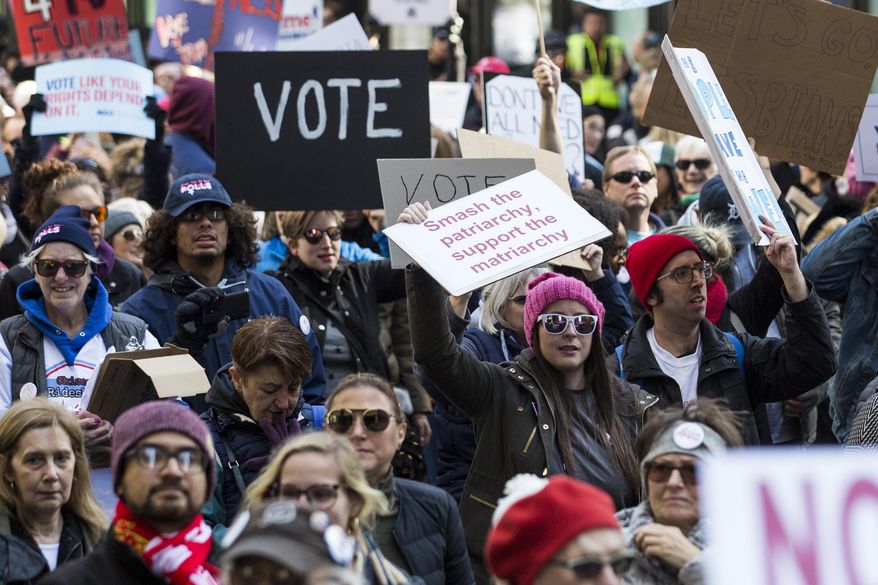 Demonstrators marched through the streets of Chicago during the Women&#x27;s March Chicago on Saturday, Oct. 13, 2018.  Thousands of people marched through downtown Chicago to express their displeasure at President Donald Trump and encourage voters to go to the polls for next month&#x27;s midterm election.  (Ashlee Rezin/Chicago Sun-Times via AP)