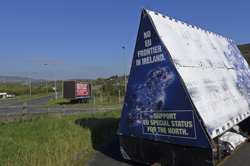 In this photo taken on Wednesday, Oct. 10, 2018, a sign in a parking lot of a cemetery reads: &amp;quot;No EU border in Ireland&amp;quot; near Carrickcarnan, Ireland, just next to the Jonesborough Parish church in Northern Ireland. The land around the small town of Carrickcarnan, Ireland is the kind of place where Britain’s plan to leave the European Union walks right into a wall - an invisible one that is proving insanely difficult to overcome. Somehow, a border of sorts will have to be drawn between Northern Ireland, which is part of the United Kingdom, and EU member country Ireland to allow customs control over goods, produce and livestock once the U.K. has left the bloc. (AP Photo/Lorne Cook)