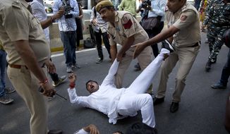 Indian policemen detain a Congress party worker during a protest against India&#39;s junior external affairs minister M.J.Akbar in New Delhi, India, Monday, Oct. 15, 2018. Akbar was accused by a dozen women of sexual misconduct when he was a newspaper editor, though he has denied any wrongdoing and has threatened to take legal action against the women, calling the allegations &amp;quot;false, baseless and wild&amp;quot; in a statement issued hours after he returned from an official trip to Africa. (AP Photo/Manish Swarup)