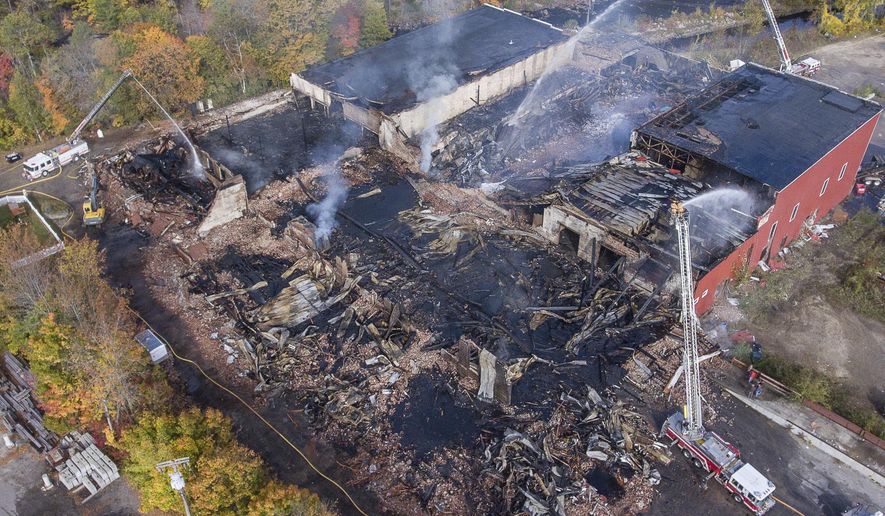 An aerial view Monday morning October 15, 2018 shows the fire scene in Mechanic Falls where a massive fire destroyed a historic mill on Sunday. The complex served several businesses, including as a warehouse for Maine Cycle, and was filled with motorcycles and parts. Corcoran Environmental Services, which recycles plastics, also operated at the mill. (Russ Dillingham/Sun Journal via AP)