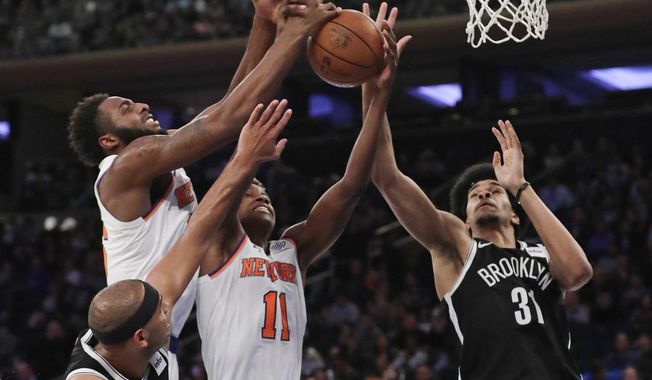 New York Knicks&#x27; Mitchell Robinson, left, and Frank Ntilikina, center, and Brooklyn Nets&#x27; Jarrett Allen (31) reach for a rebound during the first half of a preseason NBA basketball game Friday, Oct. 12, 2018, in New York. (AP Photo/Frank Franklin II)