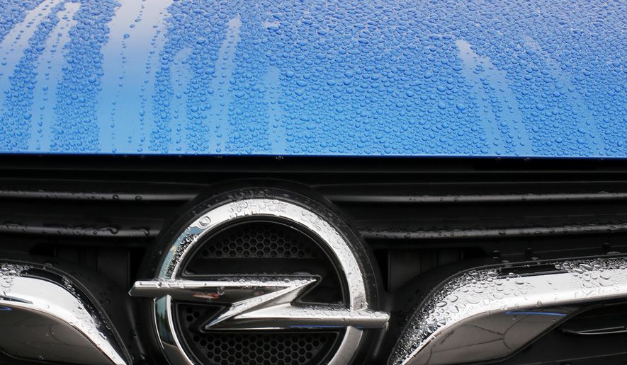 FILE - This Thursday, Nov. 9, 2017 file photo shows an Opel logo of an Opel Grandland at the Opel headquarters in Ruesselsheim, Germany. German prosecutors said Monday Oct. 15, 2018, that law enforcement officials have conducted searches at automaker Opel as part of an investigation into suspected manipulation of diesel emissions. (AP Photo/Michael Probst, File)