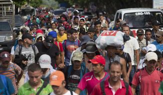 Honduran migrants walk toward the U.S. as they arrive at Chiquimula, Guatemala, Tuesday, Oct. 16, 2018. U.S. President Donald Trump threatened on Tuesday to cut aid to Honduras if it doesn&#39;t stop the impromptu caravan of migrants, but it remains unclear if governments in the region can summon the political will to physically halt the determined border-crossers. (AP Photo/Moises Castillo)