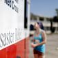 Crystal Williams receives food from the Red Cross outside a damaged motel, Tuesday, Oct. 16, 2018, in Panama City, Fla., where many residents continue to live in the aftermath of Hurricane Michael. (AP Photo/David Goldman)