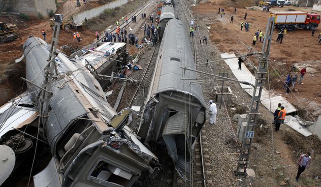 People gather after train derailed Tuesday Oct.16, 2018 near Sidi Bouknadel, Morocco. A shuttle train linking the Moroccan capital Rabat to a town further north on the Atlantic coast derailed Tuesday, killing several people and injuring dozens, Moroccan authorities and the state news agency said. (AP Photo/Abdeljalil Bounhar)