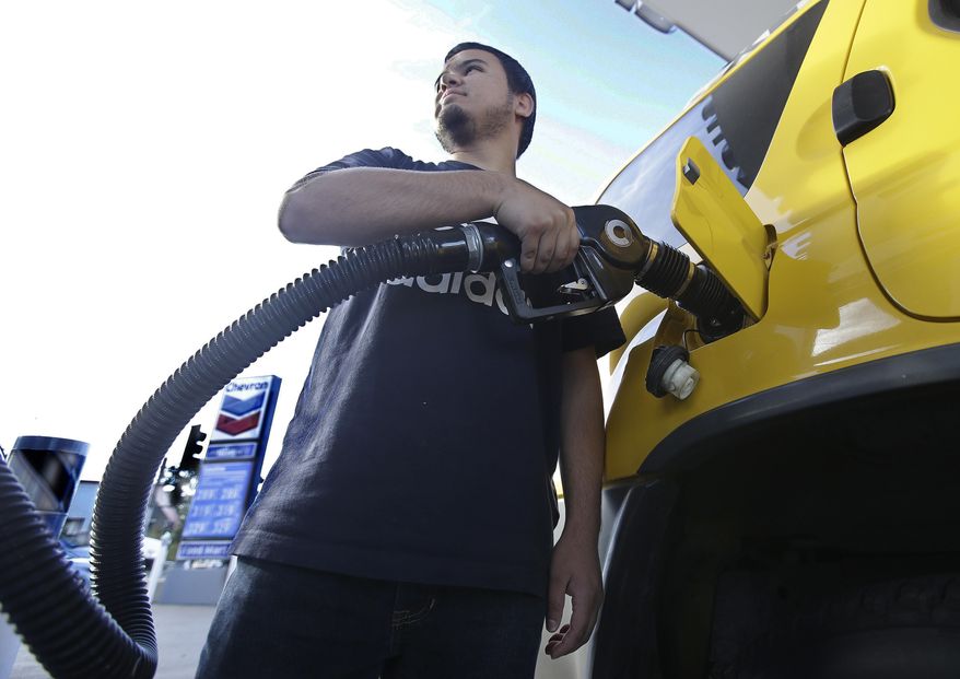 In this Oct. 30, 2017, file photo, Cristian Rodriguez fuels his vehicle in Sacramento, Calif. (AP Photo/Rich Pedroncelli, File)