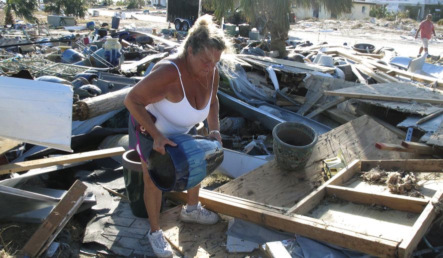 In this Oct. 14, 2018 photo Dena Frost salvages an unbroken clay pot from the wreckage of her pottery business in Mexico Beach, Fla. For decades, the town has persisted as a stubbornly middlebrow enclave on what residents proudly refer to as Florida&#x27;s &amp;quot;Forgotten Coast.&amp;quot; Businesses are locally owned. While some locals owned posh homes that overlooked the beach on stilts, many lived in mobile homes. (AP Photo/Russ Bynum)