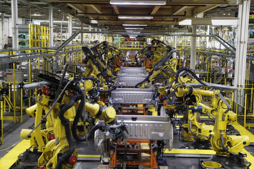 FILE- In this Sept. 27, 2018, file photo robots weld the bed of a 2018 Ford F-150 truck on the assembly line at the Ford Rouge assembly plant in Dearborn, Mich. On Tuesday, Oct. 16, the Federal Reserve reports on U.S. industrial production for September. (AP Photo/Carlos Osorio, File)