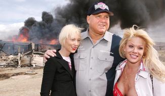 FILE - In this March 25, 2007, file photo, Moonlite Bunnyranch brothel owner Dennis Hof poses with two of his &amp;quot;working girls&amp;quot; Brooke Taylor, left, and a woman working under the name &amp;quot;Airforce Amy&amp;quot;, right, as firefighters burn down remains of the former Mustang Ranch 2 brothel east of Reno, Nev. Hof, a legal pimp who has fashioned himself as a Donald Trump-style Republican candidate has died, Nevada authorities said Tuesday, Oct. 16, 2018. (AP Photo/Debra Reid, file)