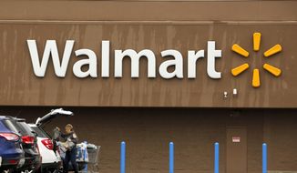 In this Feb. 22, 2018, file photo, a shopper loads her car after shopping at a Walmart in Pittsburgh. (AP Photo/Gene J. Puskar, File)